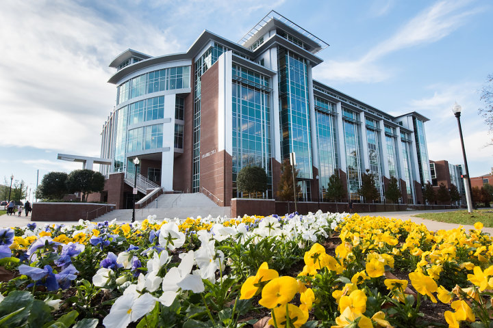 新UTC图书馆大楼的照片，前景是一个色彩鲜艳的花坛.